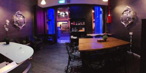 新加坡亚特兰蒂斯豆荚旅馆@小印度的一间酒吧,在房间内配有木桌和椅子