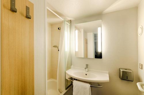 大峡谷B&B HOTEL Rouen Parc des Expos Zénith的白色的浴室设有水槽和淋浴。
