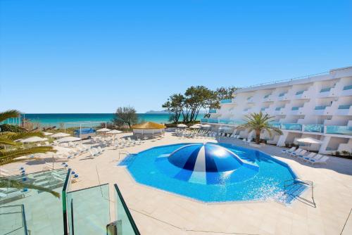 穆罗海滩伊波罗之星穆罗海滩酒店的一个带游泳池、椅子和遮阳伞的酒店