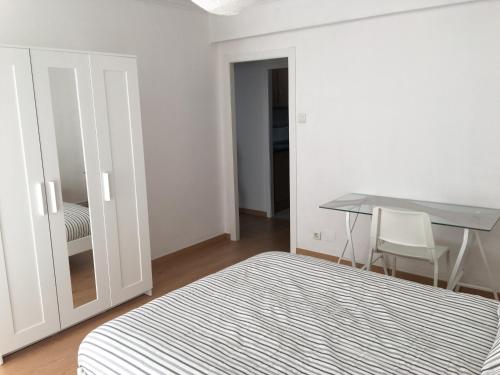 韦斯卡Apartamento Huesca en Paseo Ramón y Cajal的一间卧室配有一张床、一张桌子和一张桌子