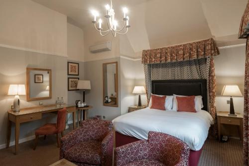 Hopwood维思特秘酒店的一间卧室配有一张床、一张桌子和一把椅子