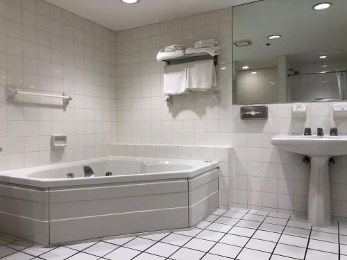 大西洋城Best Western Atlantic City Hotel的白色的浴室设有浴缸和水槽。