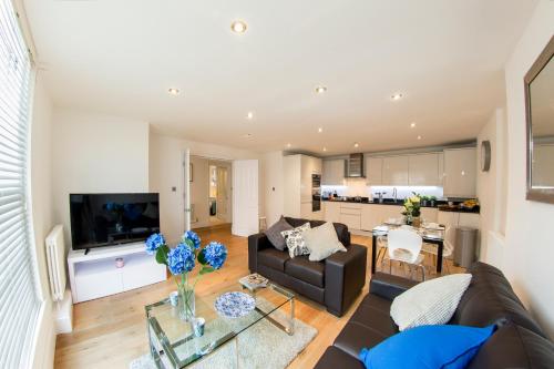 亨顿Finchley Central - Luxury 2 bed ground floor apartment的客厅配有沙发和桌子