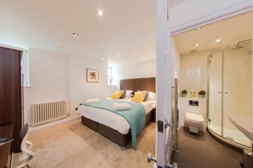 亨顿Finchley Central - Luxury 2 bed ground floor apartment的一间卧室设有一张床和一间浴室。