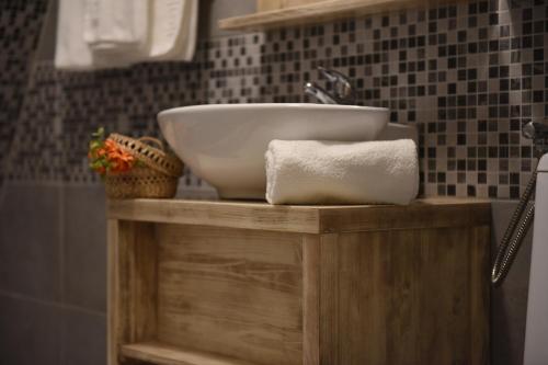 科伦德Arcso Fogado的浴室水槽位于木架上,配有毛巾