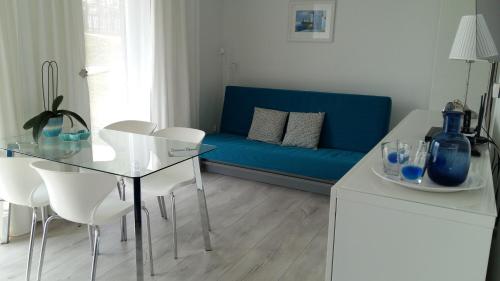 梅彻林基Klif & Mechelinki的客厅配有蓝色的沙发、桌子和椅子