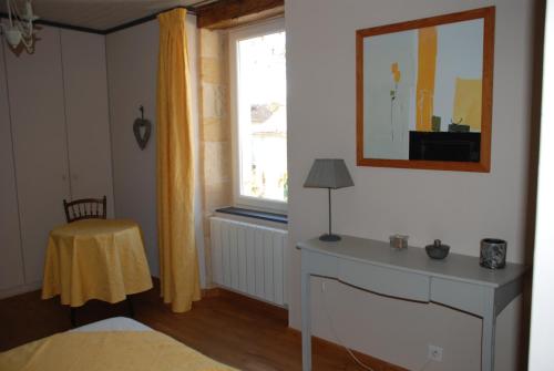 米拉克Maison d' hôtes individuelle La Relinquière的一间卧室设有一张床、一个窗口和一张桌子
