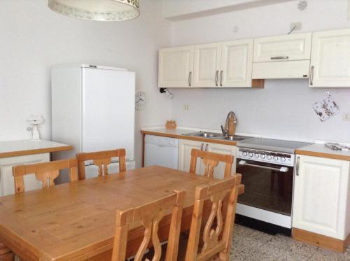 卡尔多纳佐Appartamento Guccio的厨房配有木桌和冰箱。