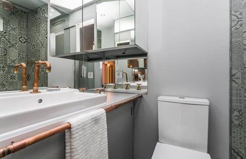 里斯本Unique Studio House | City Centre的一间带水槽、卫生间和镜子的浴室