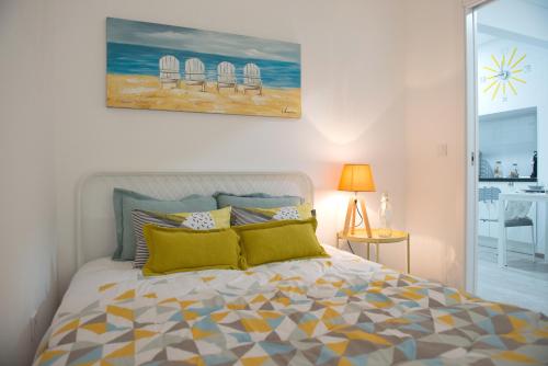 塞辛布拉Tropical house的卧室配有一张床,墙上挂有绘画作品