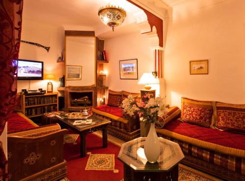马拉喀什谢里哈尼摩洛哥传统庭院住宅的客厅配有沙发和桌子
