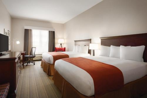 皮内拉斯公园佛罗里达州克利尔沃特 - 圣彼得堡卡尔森江山旅馆套房酒店的酒店客房设有两张床和一台平面电视。