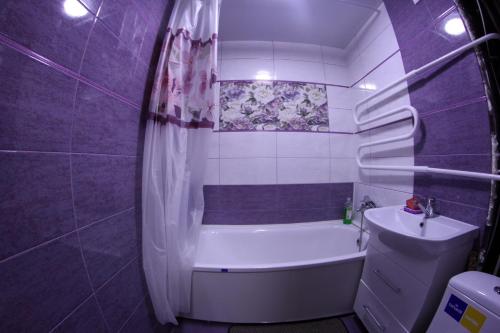 克洛佩夫尼茨基Карла Маркса的紫色浴室设有浴缸和水槽