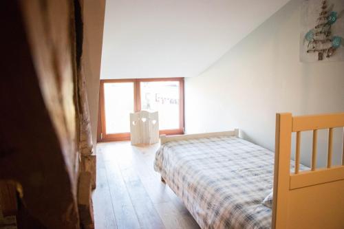 Bras-HautA la Grange d'en Haut的一间卧室设有一张床和一个窗口