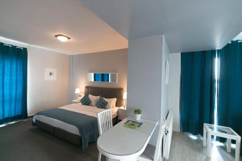 安曼康罗伊精品酒店的一间卧室配有一张床、一张桌子和一张书桌