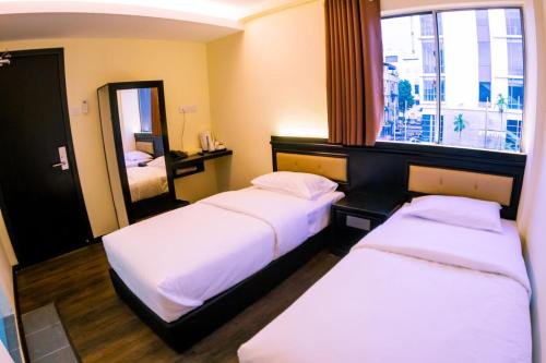 诗巫苏拉酒店的酒店客房,设有两张床和镜子