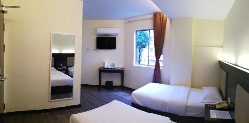 诗巫苏拉酒店的酒店客房,设有两张床和镜子