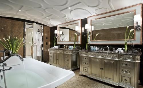 上海上海静安昆仑大酒店的浴室配有2个盥洗盆、浴缸和镜子