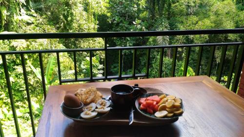 德格拉朗Bali Jungle Resort的阳台上桌上的早餐盘