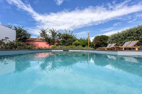 大里贝拉Quinta dos Peixes Falantes的一个带椅子和蓝天的大型游泳池