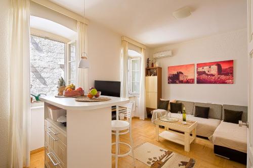 布德瓦Portun Apartment的一间带厨房的客厅和一间带沙发的客厅