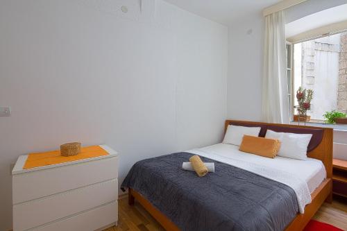 布德瓦Portun Apartment的一间卧室配有带梳妆台和窗户的床。
