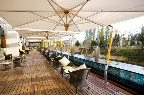 约翰内斯堡Pivot Hotel Montecasino的甲板上的一排椅子和遮阳伞
