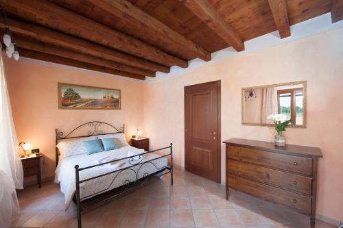 明乔河畔的瓦雷奇奥天鹅酒店的一间卧室设有一张床和木制天花板