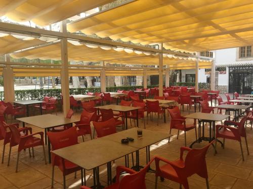 阿尔卡拉德尔胡卡尔Hostal Rural Rambla的一间空餐厅,配有桌子和红色椅子