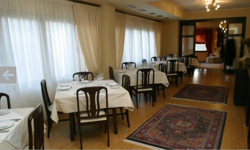 韦里亚马其顿酒店的一间设有白色桌椅和窗户的用餐室
