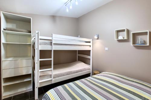 阿卡雄Location avec terrasse的一间卧室配有两张双层床和一张床