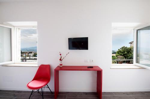 雷卡纳蒂CalaLaNotte的窗户间里的一个红色桌子和红色椅子
