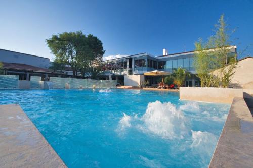 乌马格Hotel Coral Plava Laguna的大楼前的蓝色海水游泳池