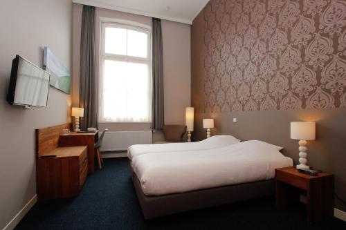 代尔夫宰尔昂德新格尔酒店的一间设有大床和窗户的酒店客房