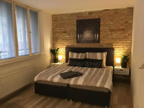 利托梅日采Theresa Apartments的一间卧室设有一张带砖墙的大床