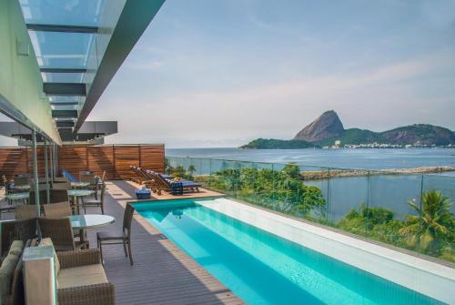 里约热内卢普罗迪吉桑托斯杜蒙酒店的一个带椅子的游泳池,享有海景