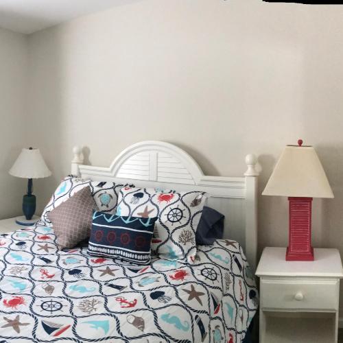 默特尔比奇Beach Escape 3的卧室配有白色的床和红灯