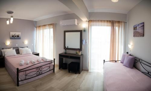 穆兹罗斯Galazio Limani - Rooms to let的一间卧室配有一张大床和镜子