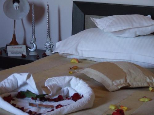 克卢日-纳波卡Pensiunea Caramell的床上有两条毛巾和水果