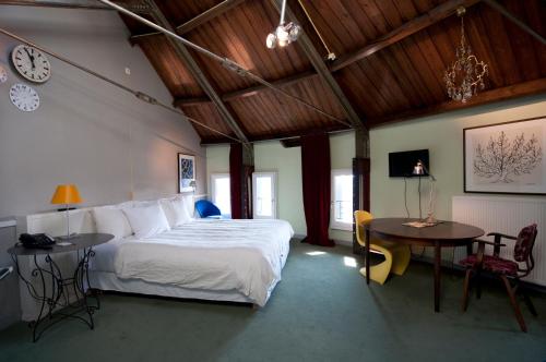 多德雷赫特奥古斯都别墅酒店的一间卧室配有一张床、一张桌子和闹钟