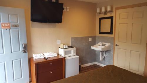 奥克兰奥克兰湾跨海大桥酒店的小房间设有水槽和微波炉
