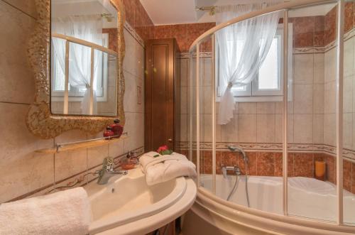 MouzákionFontana Holiday Home的带浴缸、水槽和镜子的浴室