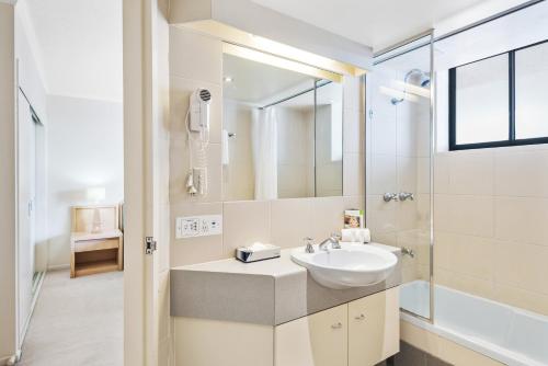 布里斯班Dockside Brisbane的白色的浴室设有水槽和淋浴。