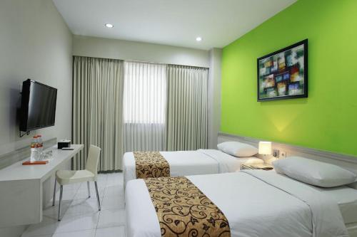 日惹瑞维莎酒店的酒店客房设有两张床和电视。