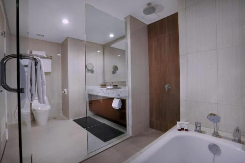 茂物The Alana Hotel and Conference Sentul City by ASTON的带淋浴、浴缸和卫生间的浴室