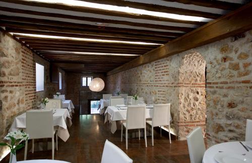Los Santos de la Humosa罗马教皇酒店的用餐室配有白色的桌子和白色的椅子