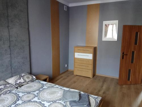 比亚韦斯托克Nordic Apartamenty Malmeda的一间卧室配有一张床、一个梳妆台和一扇窗户。