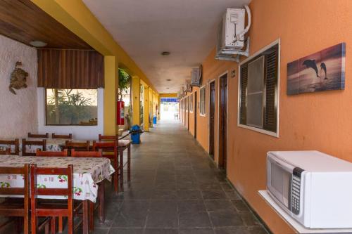 乌巴图巴Pousada Mar Virado的带有桌子和微波炉的餐厅走廊
