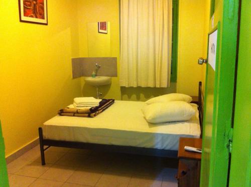 雅典宙斯旅馆的一间卧室配有一张带水槽和黄色墙壁的床