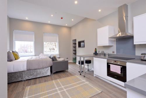 格拉斯哥纳尔逊曼德拉广场命运苏格兰公寓的厨房以及带床和沙发的客厅。
